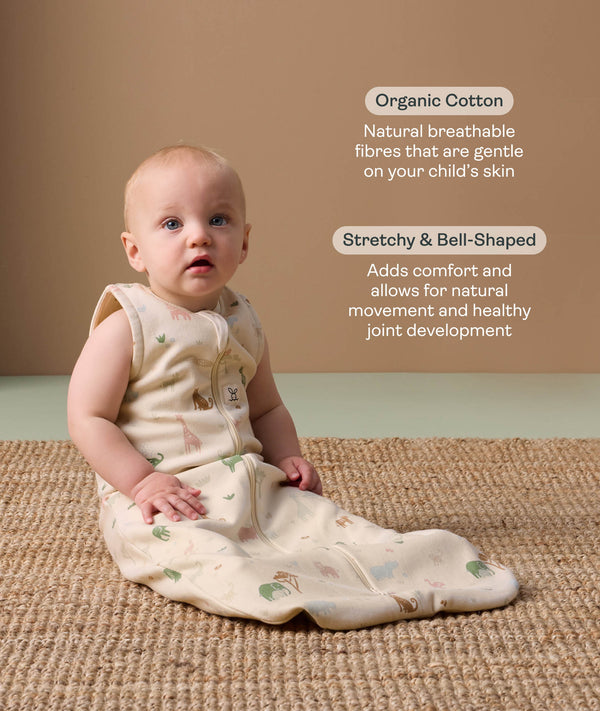 Baby wearing a sleeveless, patterned sleeping  bag sits on a woven rug, accompanied by product feature callouts for 