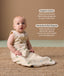 Baby wearing a sleeveless, patterned sleeping  bag sits on a woven rug, accompanied by product feature callouts for 
