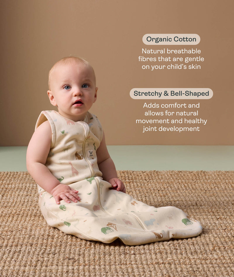 Baby wearing a sleeveless, patterned sleeping  bag sits on a woven rug, accompanied by product feature callouts for 