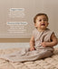 Smiling infant dressed in a sleeveless Sleeping Bag 1.0 TOG Taupe Marle, sitting on a quilted mat with text highlighting 