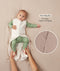 A baby lying down in a green long sleeve layer with an unzipped beige sleeping bag while adult hands hold their feet. Text highlighting 