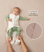 A baby lying down in a green long sleeve layer with an unzipped beige sleeping bag while adult hands hold their feet. Text highlighting 