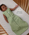 Infant lying in a wooden cot wearing a sleeveless Sleeping Bag 1.0 TOG Willow with text highlighting slim-fit design for an easy transition from swaddling.