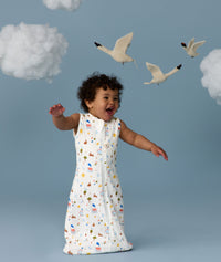 Infant in a cool ergoPouch Sleeping Bag 1.0 TOG Daydream with birds and clouds in the background, perfect for everyday