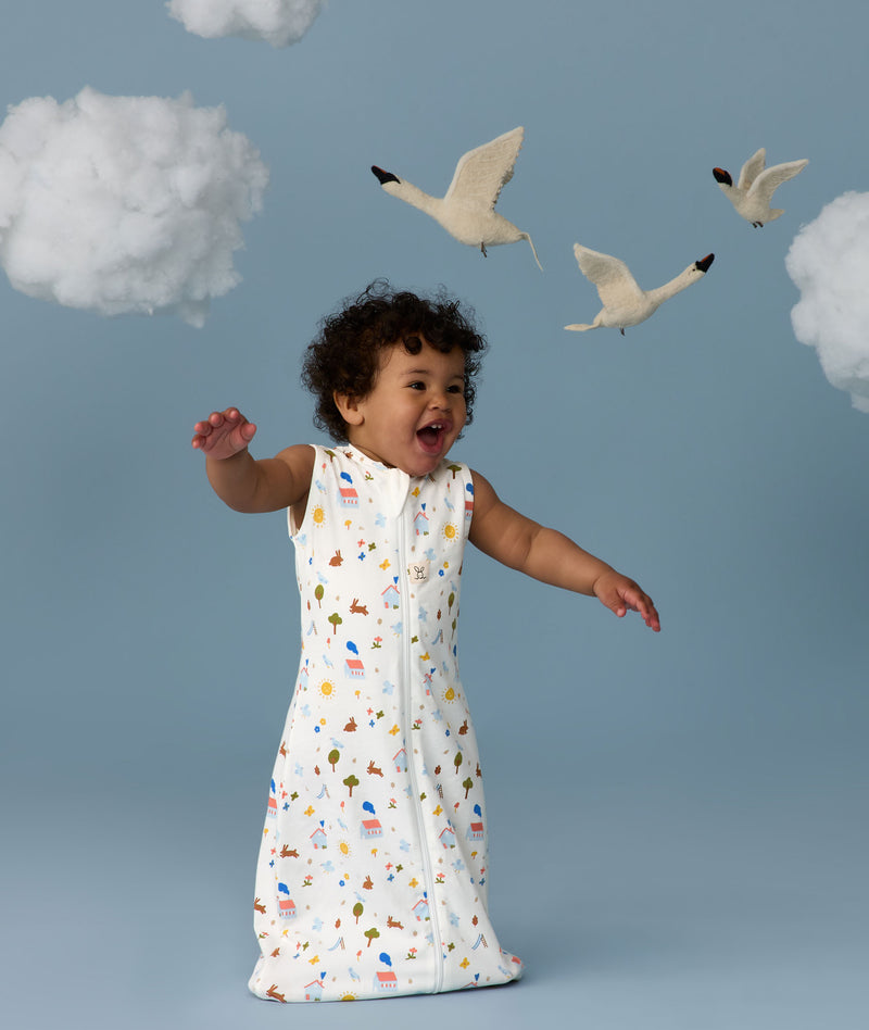 Infant in a cool ergoPouch Sleeping Bag 1.0 TOG Daydream with birds and clouds in the background, perfect for everyday