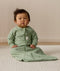 Infant wearing an ergoPouch Sleeping Bag 1.0 TOG Sleeved Willow