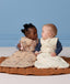 Two infants sitting side by side wearing ergoPouch Sleeping Bag 2.5 TOG in Melody and Lullaby