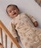 Baby lying in a cot wearing a printed Sleeping Bag 3.5 TOG Sleeved Melody