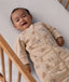 Baby lying in a cot wearing a printed Sleeping Bag 3.5 TOG Sleeved Melody