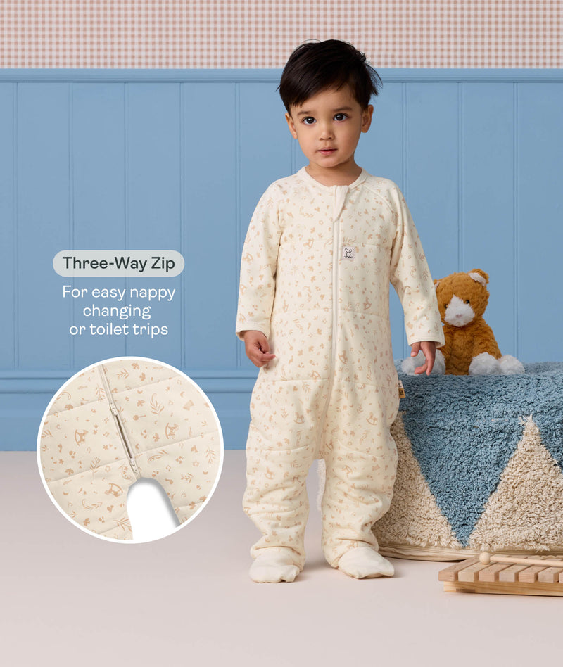 Toddler standing in a cream patterned 2.5 TOG Sleep Onesie, beside a callout diagram and text showcasing a 
