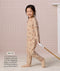 Preschooler walking while pulling a wooden toy, wearing a slim-fit beige patterned Sleep Onesie, with text describing its design for toddlers and preschoolers.