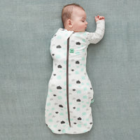 Baby wearing a Cocoon Swaddle Bag 1.0 TOG Clouds, with one arm out