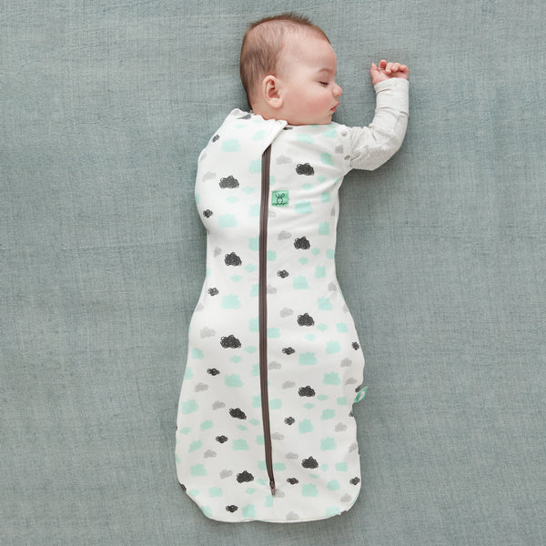 Baby wearing a Cocoon Swaddle Bag 1.0 TOG Clouds, with one arm out