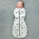 A sleeping baby wearing a Cocoon Swaddle Bag 1.0 TOG Clouds