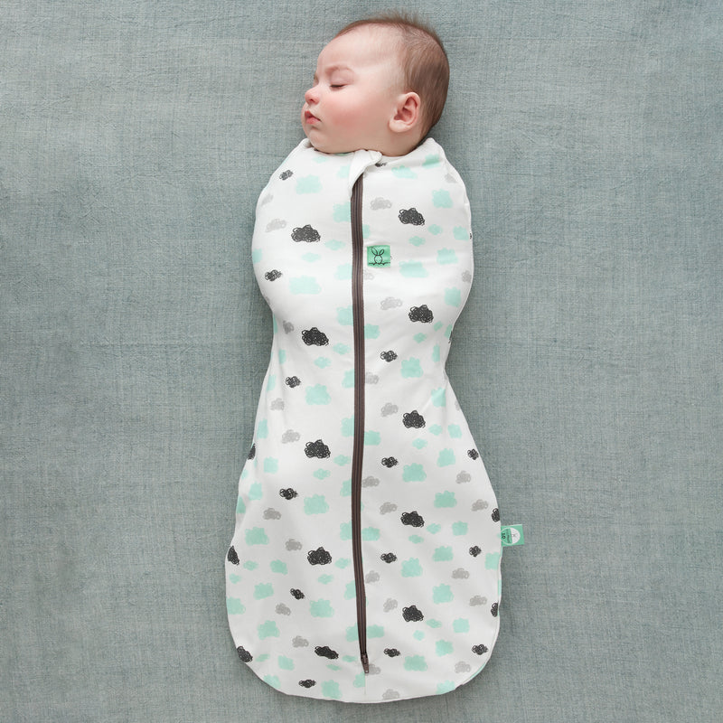 A sleeping baby wearing a Cocoon Swaddle Bag 1.0 TOG Clouds