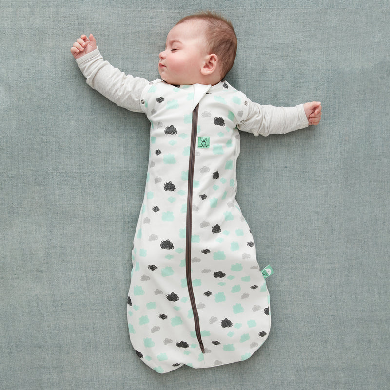 Baby wearing a Cocoon Swaddle Bag 1.0 TOG Clouds, with arms out
