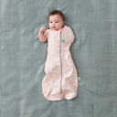 Baby wearing a Cocoon Swaddle Bag 1.0 TOG Spring Leaves, with one arm out