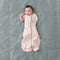 Baby wearing a Cocoon Swaddle Bag 1.0 TOG Spring Leaves, with one arm out
