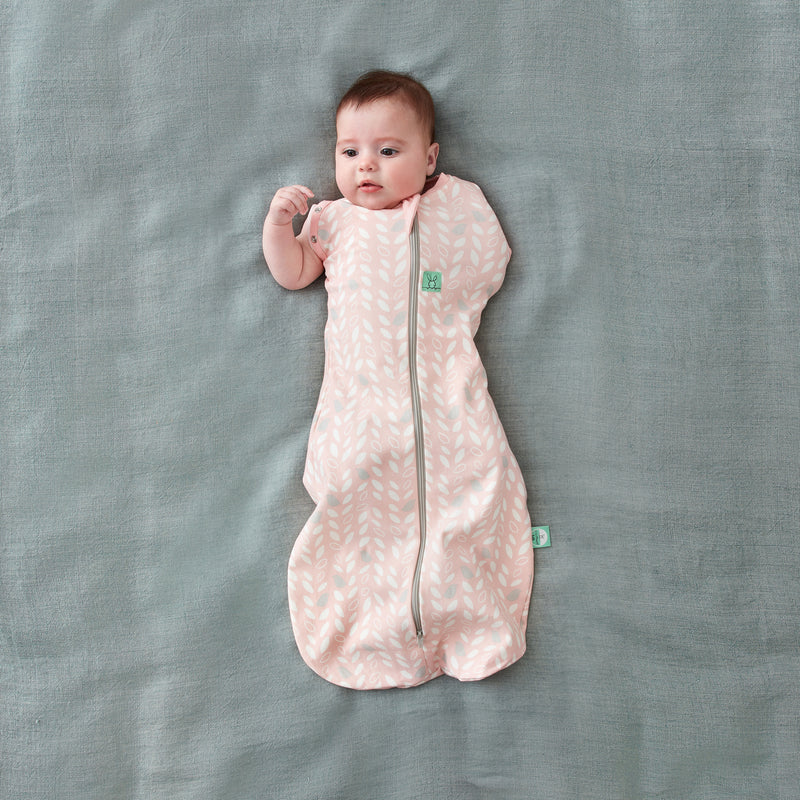 Baby wearing a Cocoon Swaddle Bag 1.0 TOG Spring Leaves, with one arm out