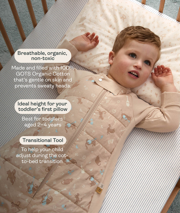 A toddler resting in a crib on a patterned pillow, with text overlays detailing features: 