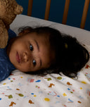 Close up of child lying on an ergoPouch Organic Toddler Pillow and Case Daydream