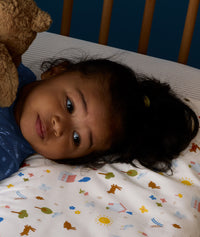 Close up of child lying on an ergoPouch Organic Toddler Pillow and Case Daydream