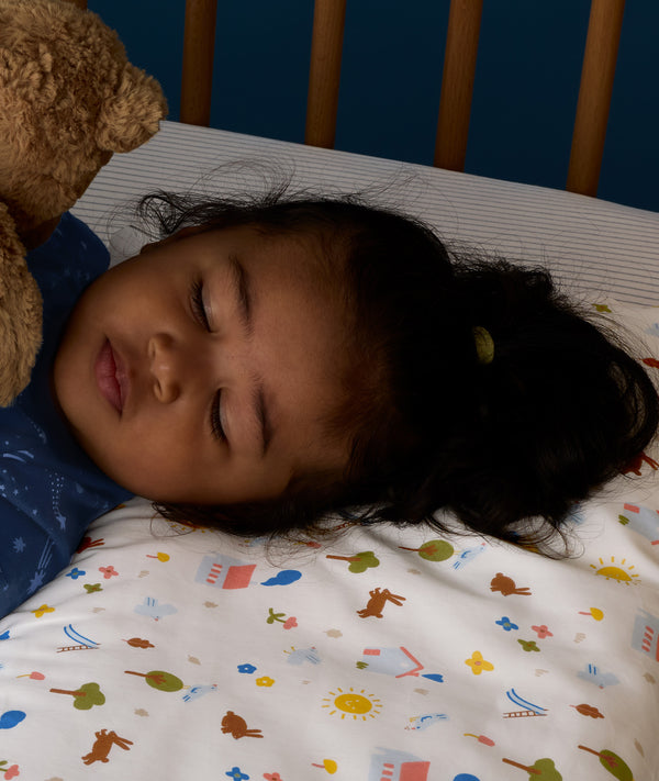 Close up of child lying on an ergoPouch Organic Toddler Pillow and Case Daydream