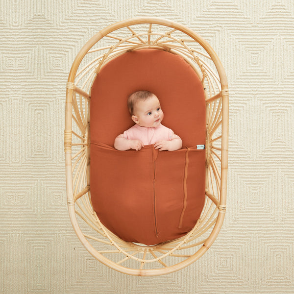Baby lying under ergoPouch HugMe Blanket 0.2 & 1.0 TOG in Rust 