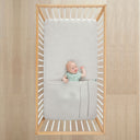 Baby lying in cot under ergoPouch HugMe Blanket 0.2 & 1.0 TOG in Grey Marle 