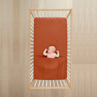 Baby sleeping under ergoPouch HugMe Blanket 0.2 & 1.0 TOG in Rust 