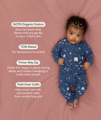 Baby wearing an ergoPouch Long Sleeve Layer 1.0 TOG Starbeam with text about GOTS Organic Cotton and product features on a pink background