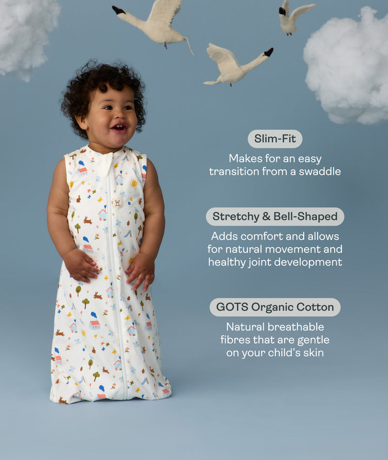 Infant wearing a ergoPouch Sleeping Bag 1.0 TOG Daydream with text about its features on a blue background with swans and clouds.