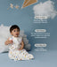 Child in an ergoPouch Sleeping Bag 1.0 TOG Daydream sitting on a blue floor with clouds and a kite, surrounded by text about product features.