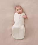 Newborn wearing an ergoPouch Cocoon Swaddle Bag 0.2 TOG Oatmeal Marle with one arm out