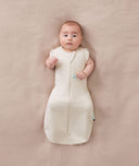 Newborn wearing an ergoPouch Cocoon Swaddle Bag 0.2 TOG Oatmeal Marle with arms out