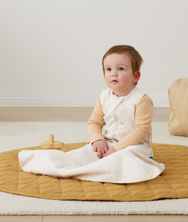 Baby with hip dysplasia siting up wearing ergoPouch Hip Harness Jersey Sleep Bag 0.2 TOG Oatmeal Marle