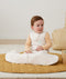Newborn sitting, wearing an ergoPouch Hip Harness Jersey Sleeping Bag 2.5 TOG Oatmeal Marle